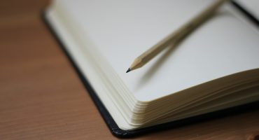 shallow focus photography of pencil on book