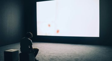 man sit in front projector screen