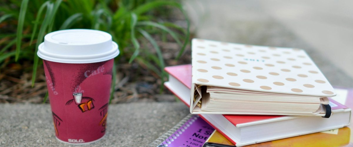 red and white cup beside book