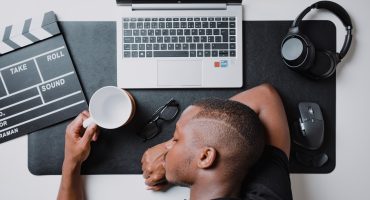 a man sitting at a desk with a laptop and headphones